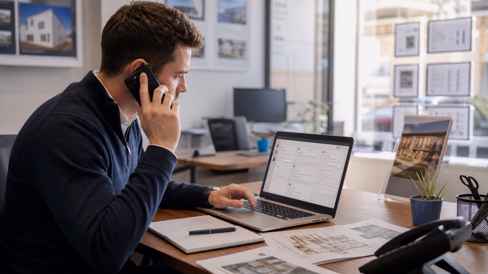 A negotiator checking buyer requirements and viewing access notes on a laptop before confirming an appointment by phone